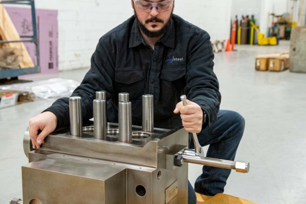 energy steel employee working on positive displacement pump_