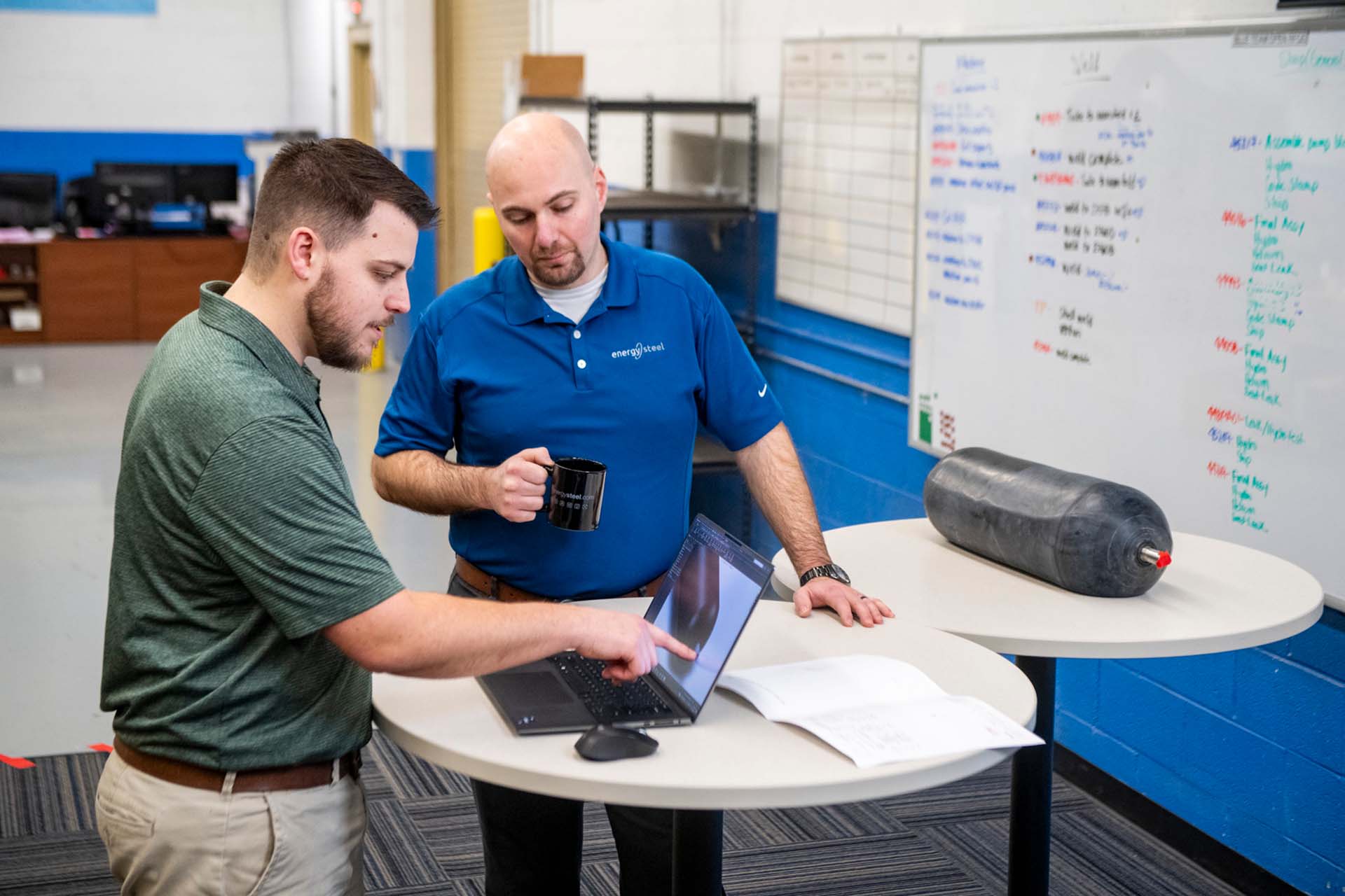 two energy steel workers at laptop