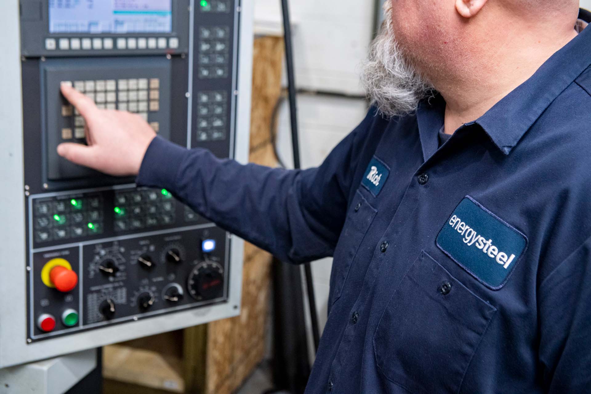 worker pressing buttons on control panel